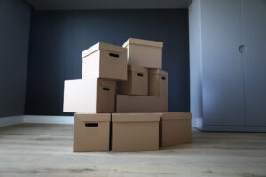 Vanonsite Empty cardboard boxes stand in an empty room. Empty office interior, boxes stand on floor. Loading property in boxes. Items are reliably protected from damage during loading and transportation