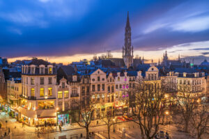 Brussels, Belgium plaza and skyline with the Town Hall tower at dusk.