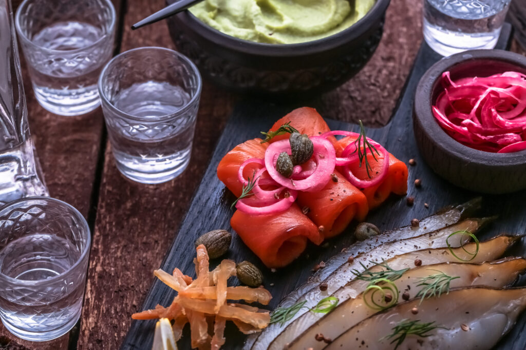 Close view of cured salmon with shots of vodka