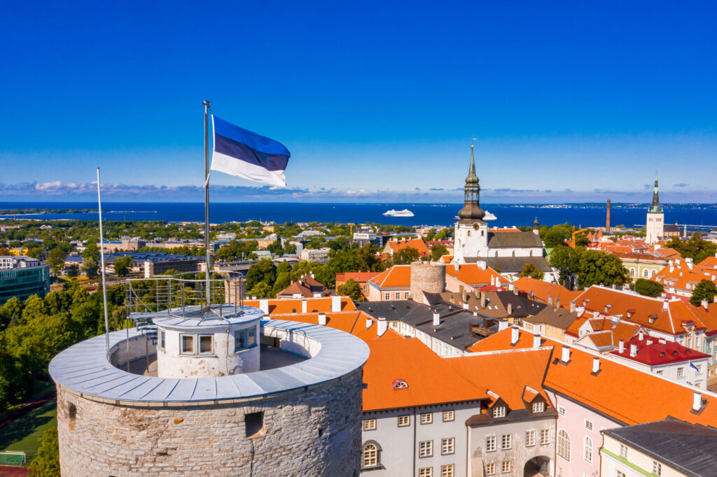 The flag of Estonia on the Tall Hermann Tower under the sunlight and a blue sky in Tallinn