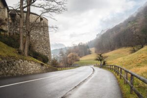 A high angle shot of a road going down a hill beside the Vaduz castle in Liechtenstein