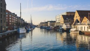 A wide shot of boats on the body of water near buildings in Christianshavn, Copenhagen, Denmark