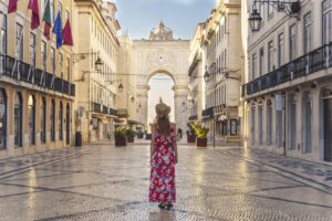 A young female in a floral dress walking around the Commerce Square in Lisbon, Portugal