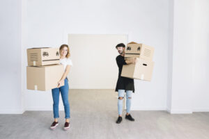 Couple holding moving boxes – preparing for a home relocation together