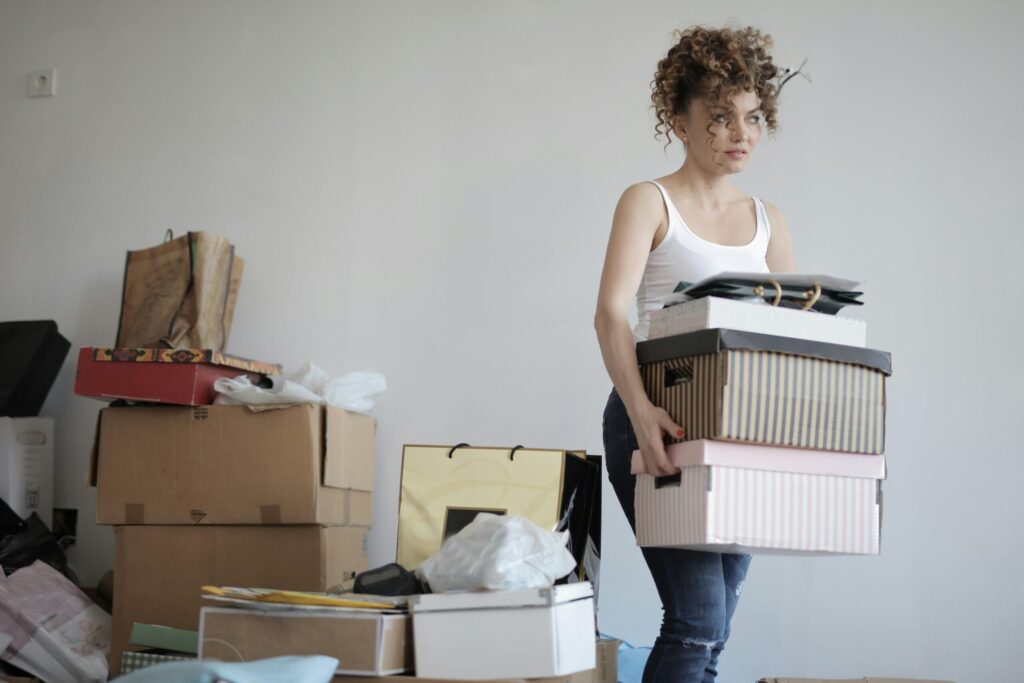 Person transporting labeled moving boxes in a UK home ahead of an international relocation to the Netherlands.