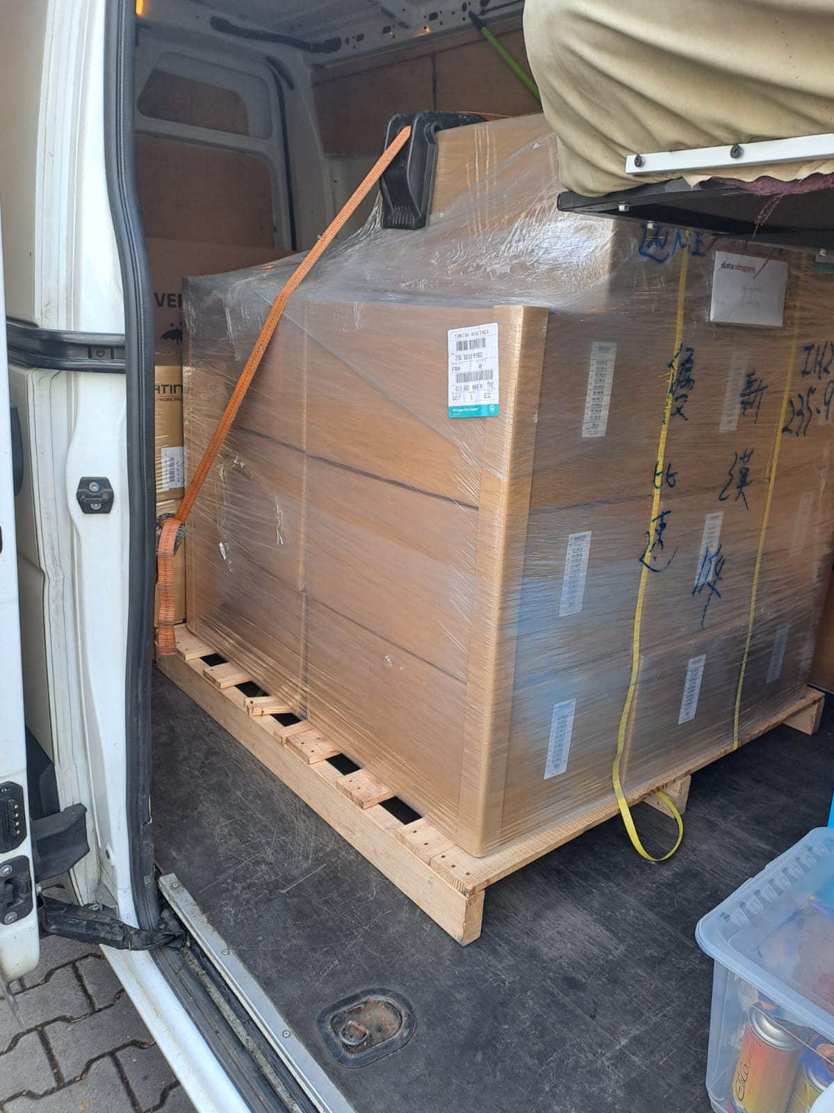 Large pallet of cardboard boxes shrink-wrapped and secured with ratchet straps inside a removal van—an example of VanOnsite’s international removals UK to Netherlands packing process.