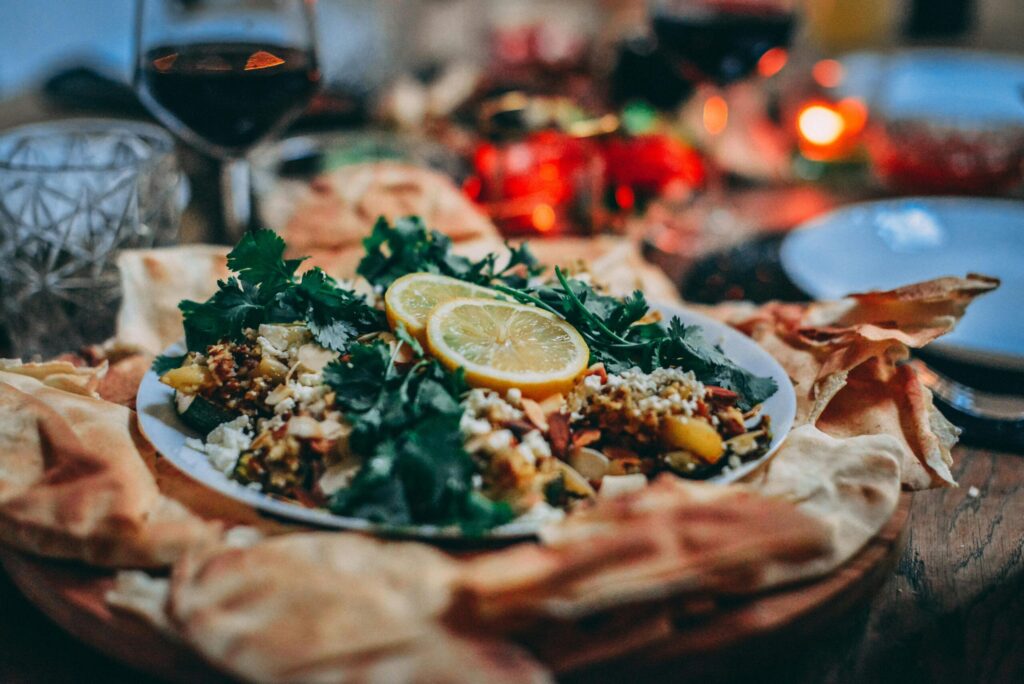 Hearty Dutch meal with fresh herbs, lemon slices, and flatbread on a rustic wooden table, illustrating life in the Netherlands cuisine.