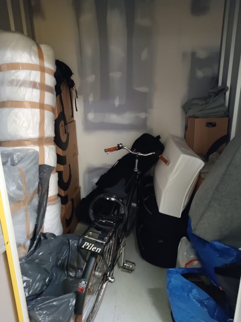 Packed bicycle, wrapped furniture, and boxes inside a container, all set for moving to Holland from UK.