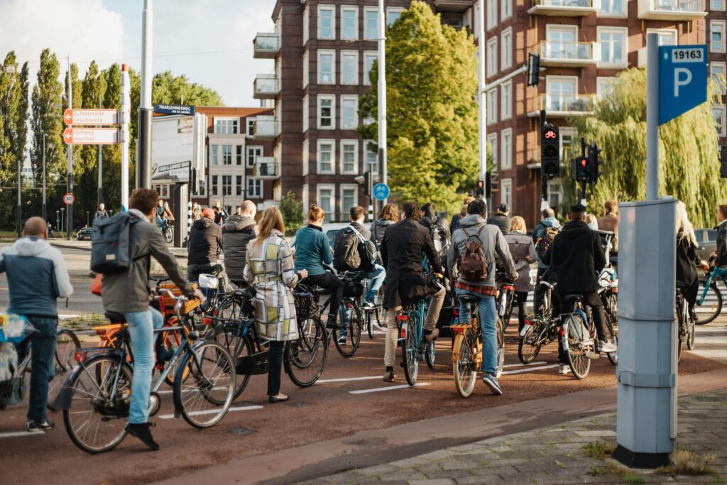 Cyclists riding past modern apartments, illustrating how a Netherlands salary supports urban living and sustainable commuting.”