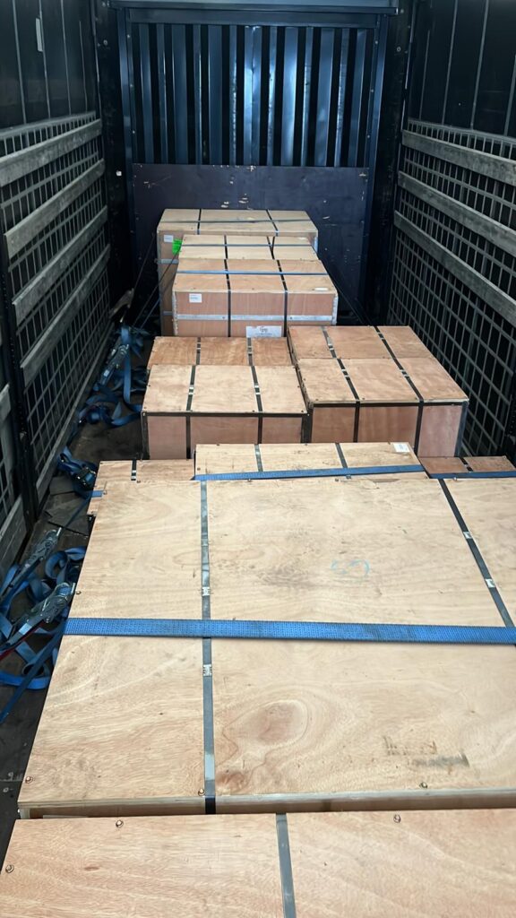 Shrink-wrapped pallet of cardboard boxes positioned against the back wall of a van, ready for small removals to Netherlands transport.
