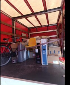 Loaded moving truck with boxes, bike and furniture secured inside, showing relocation from Denmark to Spain with VANonsite.