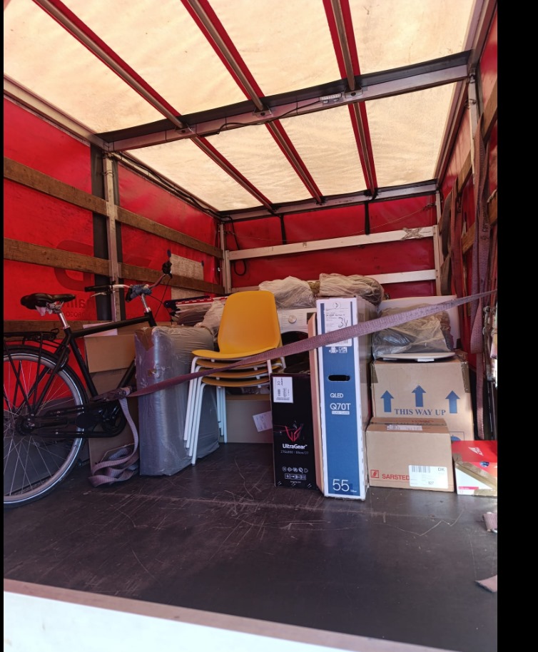 Loaded moving truck with boxes, bike and furniture secured inside, showing relocation from Denmark to Spain with VANonsite.