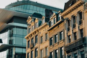 Traditional Brussels townhouses next to a modern glass office building, showing the mix of old and new architecture you can enjoy after moving to Belgium with VANonsite European removals