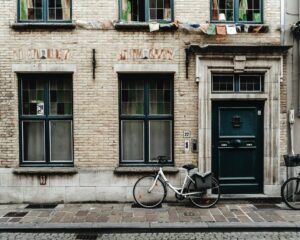 Bicycle parked outside a traditional brick townhouse in Belgium, showing everyday street life you can enjoy after moving to Belgium with VANonsite European removals