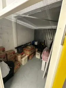 VANonsite storage unit with neatly stacked moving boxes and bags prepared for secure short term and long term storage during European removals